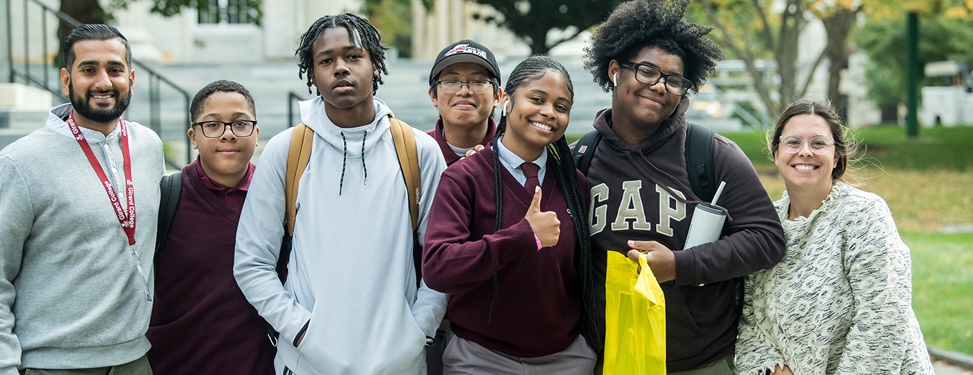 students outside smiling at a camera