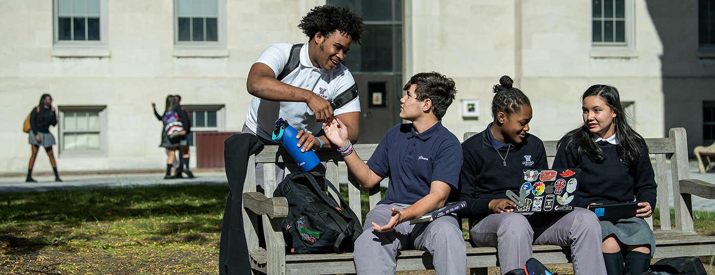 students outside sitting on a bench