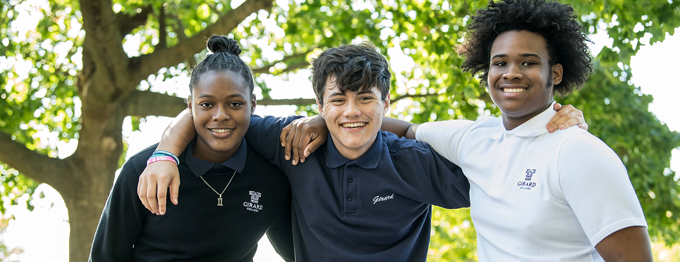 students outside smiling at the camera