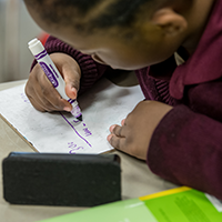 student writing on a paper