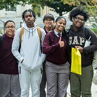 students outside smiling at a camera