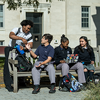 students outside sitting on a bench