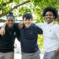 students outside smiling at the camera